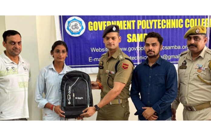A police officer distributing school bag kits among students at Government Polytechnic College Samba on Thursday.