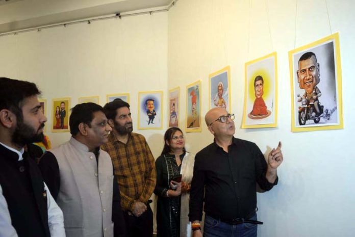 Cartoonist Chandra Shekhar showing his caricatures to the dignitaries during an exhibition at Kala Kendra, Jammu.