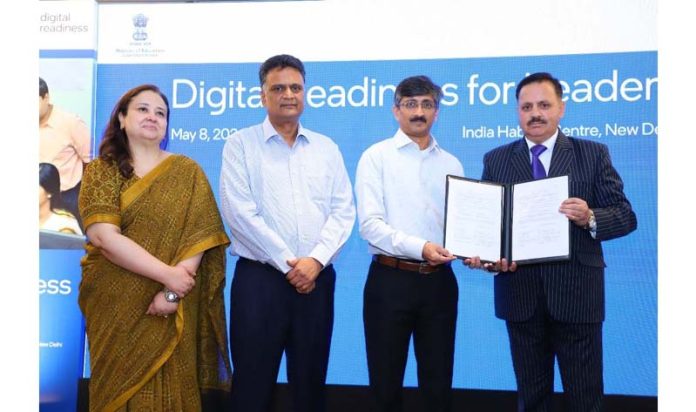 Officers displaying copies of MoU signed between KU and Intel India.