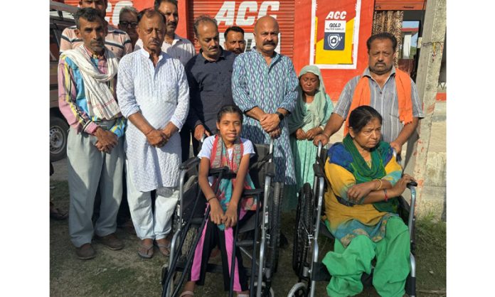 BJP vice president, Yudhvir Sethi distributing wheel chairs among specially abled persons at Dhammi Jagti on Saturday.