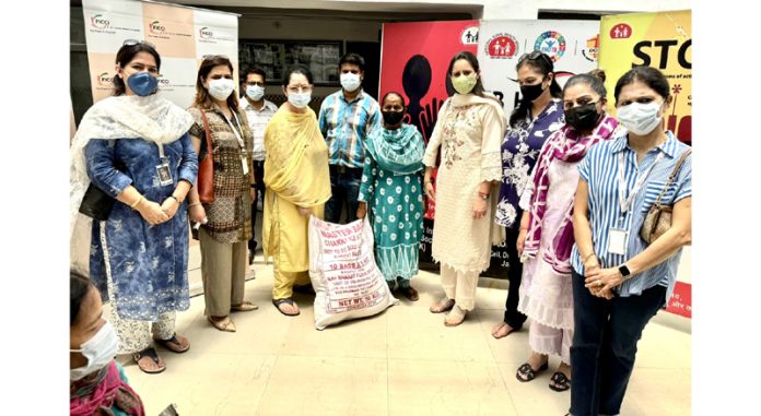 Members of FICCI FLO JKL posing with a TB patient after providing her a nutrition kit.