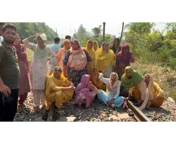 Women protestors sitting on Railway track near Hiranagar on Monday against the murder of a youth in village Mela -Excelsior/ Pardeep