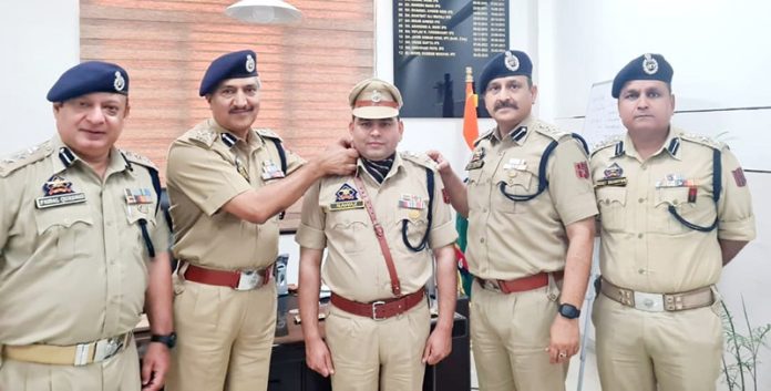 DIG Traffic Jammu, Dr Mohammad Haseeb Mughal, decorating a police officer with the new rank at Traffic Police Range Headquarters, Jammu on Saturday.