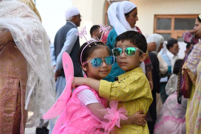 Children greet each other after Eid prayers at Hazratbal, Srinagar. -Excelsior/Shakeel