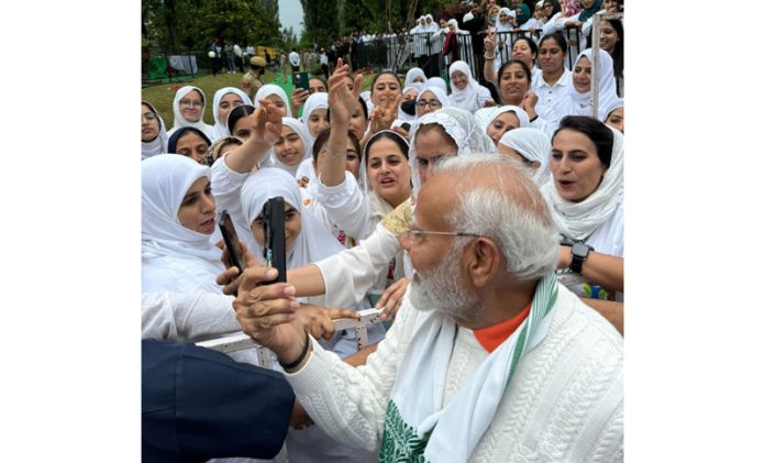 Prime Minister Narendra Modi takes a selfie with students after performing yoga on the occasion of 10th International Yoga Day in Srinagar on Friday. (UNI)