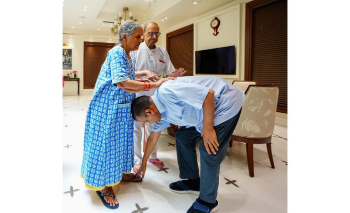 Delhi Chief Minister Arvind Kejriwal taking the blessings of his parents before leaving from his residence, to surrender before Tihar jail authorities, in New Delhi on Sunday. (UNI)