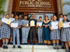 Students of KCPS displaying certificates while posing with teaching faculty.