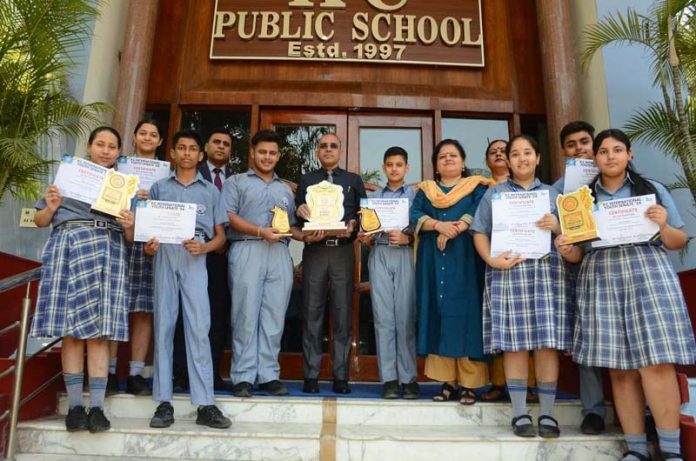 Students of KCPS displaying certificates while posing with teaching faculty.