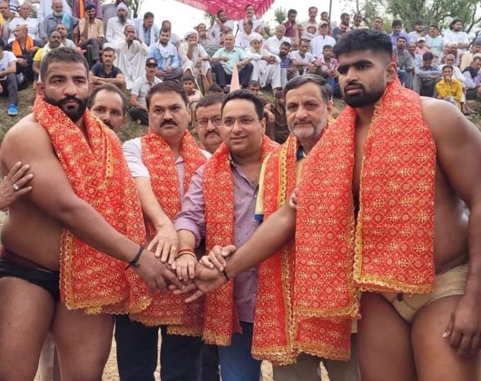 Dignitaries posing along with wrestlers during a dangal event at Reasi.