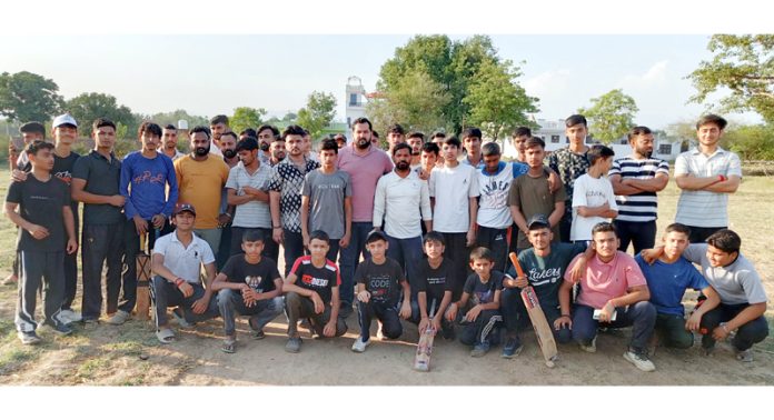 Young players posing with organisers during a cricket tournament.