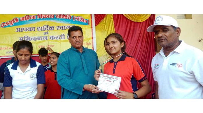 A student of Patanjali Gurukulam receiving certificate from dignitary.