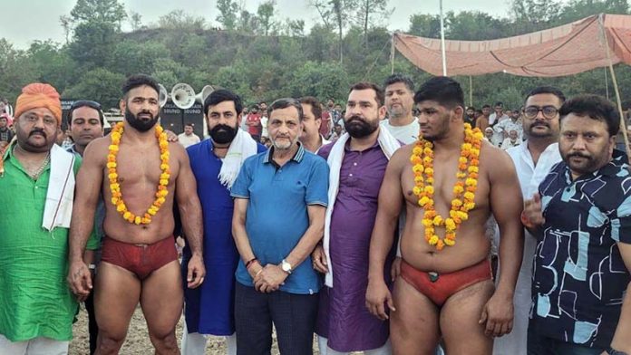 Wrestlers posing along with dignitaries during Dangal event.
