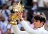 Carlos Alcaraz holding trophy after defeating Novak Djokovic in the Wimbledon men’s singles final in London on Sunday.