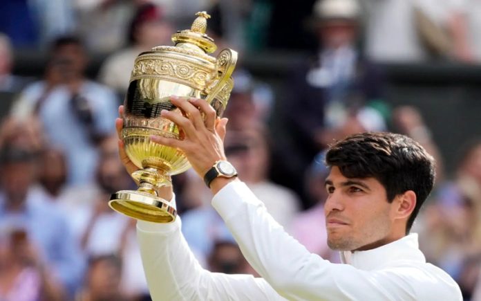 Carlos Alcaraz holding trophy after defeating Novak Djokovic in the Wimbledon men’s singles final in London on Sunday.