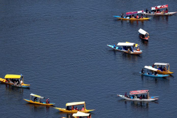 Beneath the brilliant blue sky on a sunny Tuesday, a fleet of Shikaras gracefully glides through the serene waters of Dal lake in Srinagar. -Excelsior/Shakeel