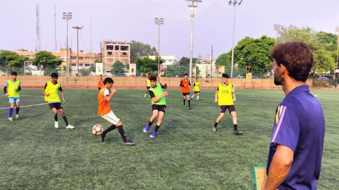 Footballers in action during selection trials at Mini Stadium, Parade Ground in Jammu.