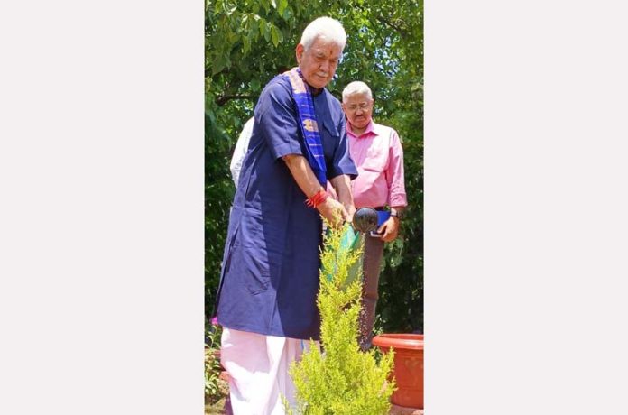 LG Manoj Sinha watering a plant during plantation drive at Raj Bhawan Srinagar on Monday.