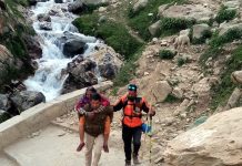 Police cop carrying Yatri on his shoulder who was unable to walk during ongoing Amarnath Yatra. 