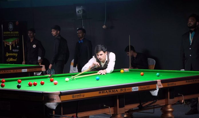 Kamran Majid displaying his skills while playing a snooker game.