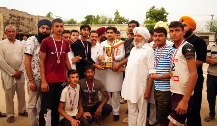 Winning team posing along with trophy and dignitaries.