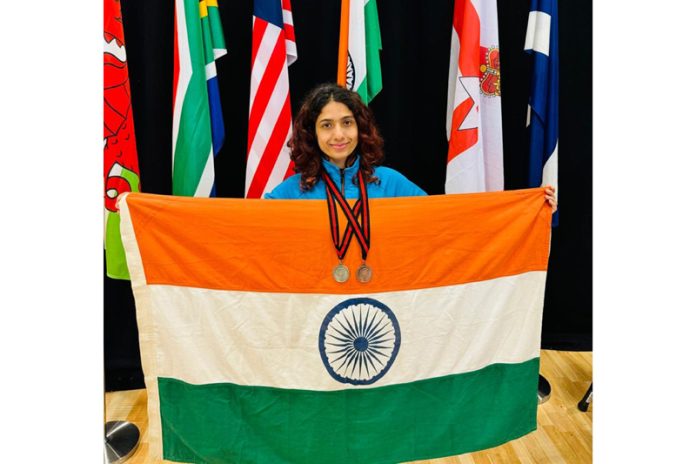 Fencer Shreya Gupta posing with National Flag and medals.