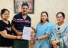 BJP leader Rekha Mahajan presenting domicile certificate to a person in Jammu South area.