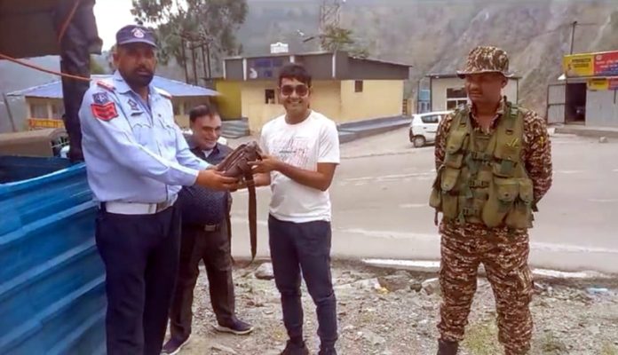 Traffic cops return the bag full of cash and valuables to its owner in Ramban on Monday.