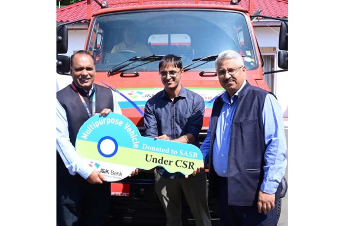 J&K Bank MD and CEO, Baldev Prakash, handing over the keys of a multi-purpose vehicle to SASB CEO, Dr Mandeep K Bhandari, at Raj Bhawan in Srinagar on Thursday.