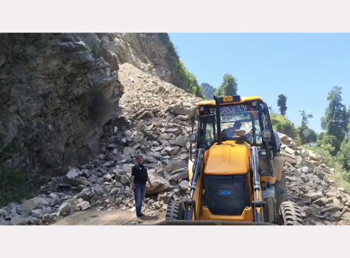A JCB clearing landslide near Panar bridge on Mughal Road in Poonch district on Monday. Excelsior/ Waseem.