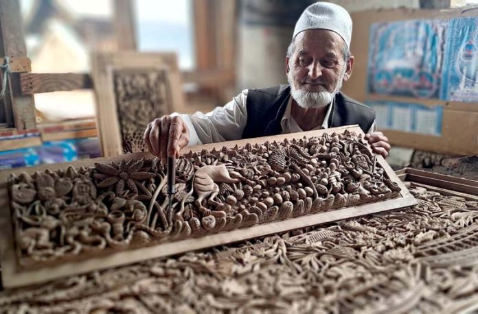 Master woodcarver Ghulam Nabi Zargar works in his workshop in Srinagar on Friday. -Excelsior/Shakeel