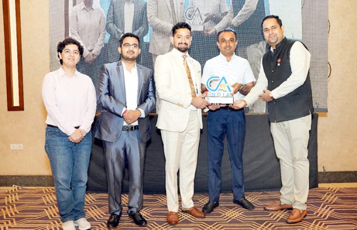 Divisional Commissioner Jammu Ramesh Kumar presenting memento to a newly qualified CA during CA Day function in Jammu.