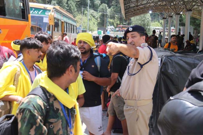 A police officer guiding the Amarnath bound pilgrims at Nunwan Base Camp on Wednesday.