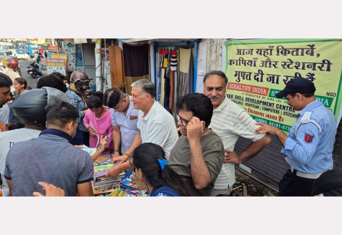 Hira Lal Abrol distributing free books and stationery items to needy students during a camp.