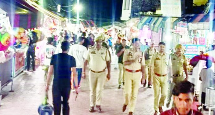 Police officers taking round of temple complex in Bagh-e-Bahu area.