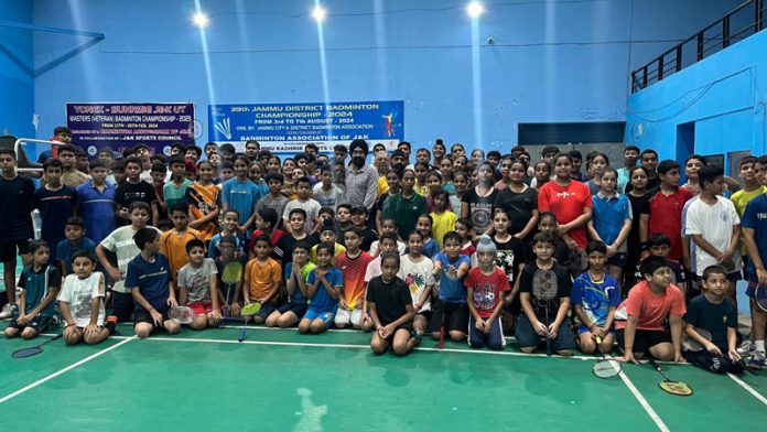 Young badminton players posing along with dignitaries during opening ceremony of district championship at MA Stadium Jammu.