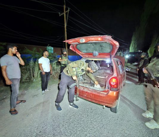 Security personnel checking a vehicle in Baramulla on Tuesday. -Excelsior/Aabid Nabi