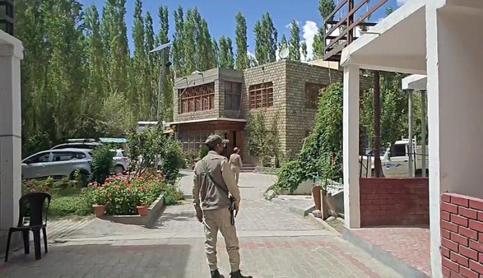 Cops stand guard outside a house searched by the ED sleuths at Leh on Friday.