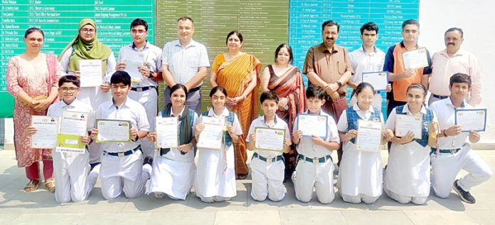 Students of DPS posing along with certificates and teaching staff.