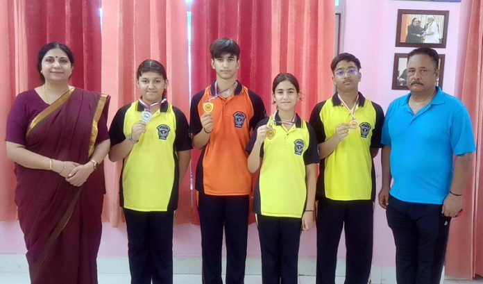 Students of DPS Jammu posing along with medals and school management.