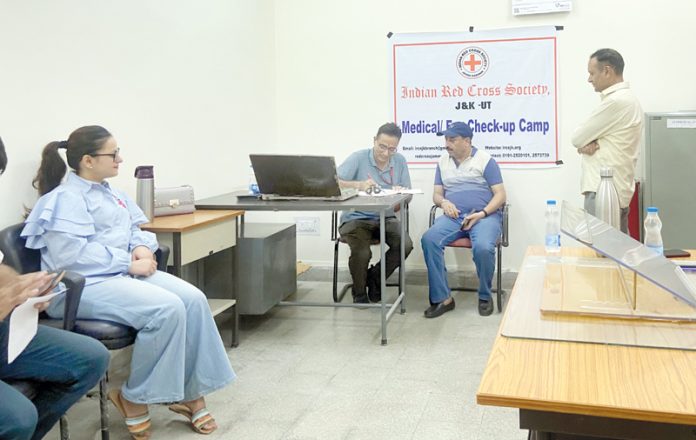 A doctor examining a patient during a medical camp organized by IRCS, J&K on Saturday.