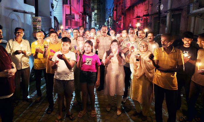 Residents of Panjtirthi area during a candle light protest on Friday.