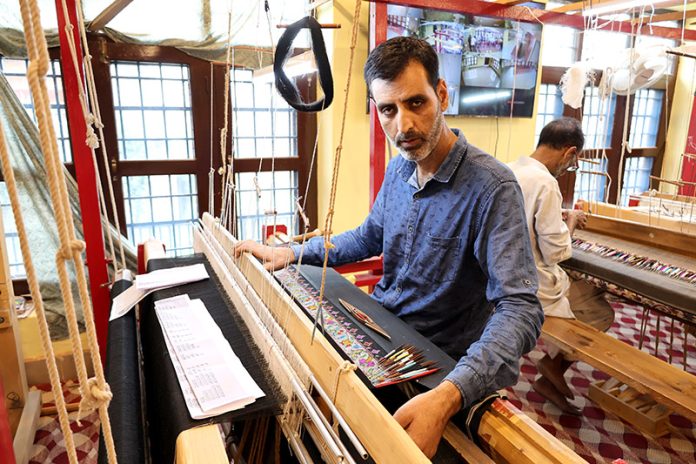 National awardee Fareed Ahmad skillfully weaving famous Kani shawl on his loom in Kanihama village of Budgam district. -Excelsior/Shakeel