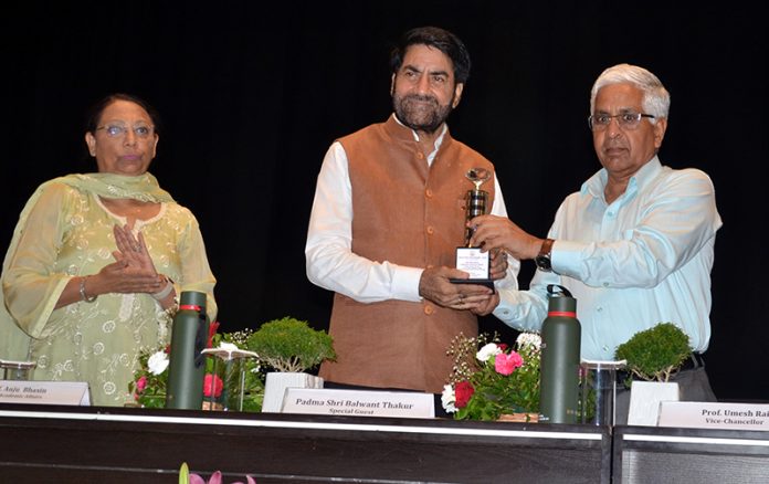 JU VC presenting a memento to Balwant Thakur during an induction programme for newly admitted students.