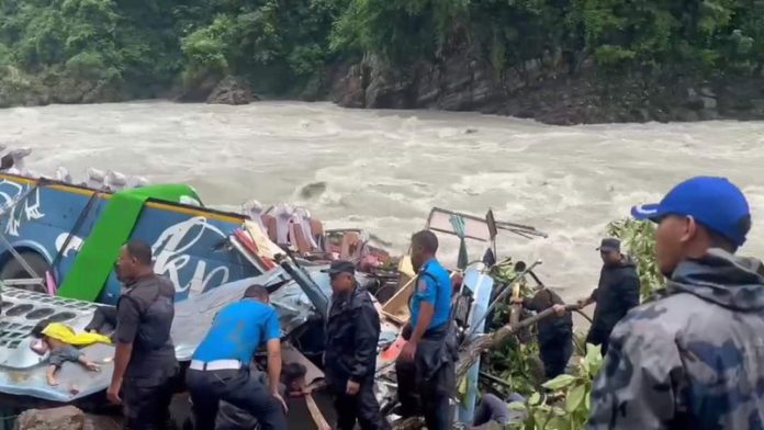 Rescue workers work at the accident site on the banks of the Marsyangdi River in Tanahun district, Nepal.