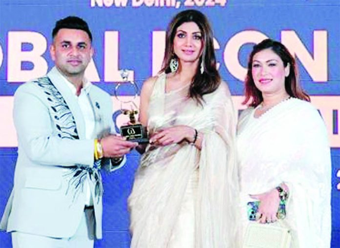 Shivam Suri, Managing Director of MRAK Jewellers getting an award from Shipla Shetty during a function held in New Delhi.