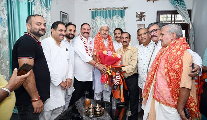 BJP candidate for the Jammu North Assembly Constituency, Sham Lal Sharma posing with his supporters at an event in village Raipur.