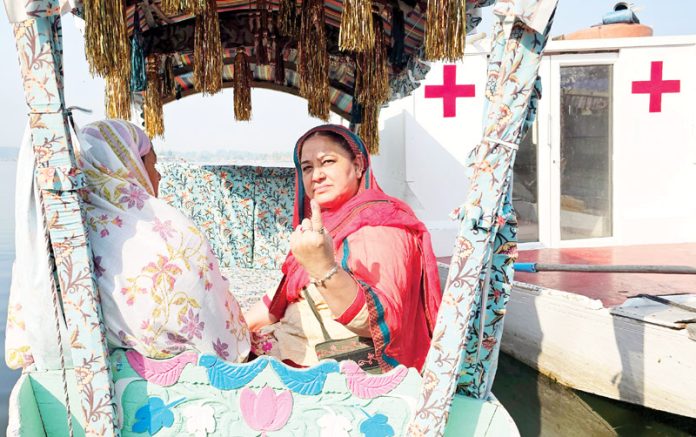 A woman showing indelible ink mark after casting ballot at a floating polling station set up on Dal lake in Srinagar on Wednesday. -Excelsior/Shakeel