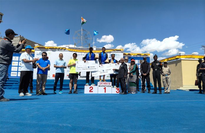 Winners posing on podium along with medals and cheques during Ladakh Marathon.