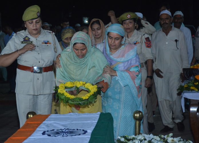 Kin of martyred HC Bashir Ahmed laying wreath on his mortal remains during wreath laying ceremony organized by J&K Police at Gulshan Ground, Jammu. —Excelsior/Rakesh