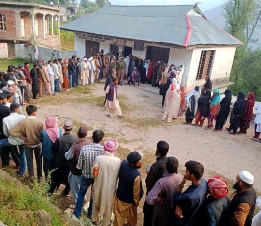 People stand in a queue to cast votes at Surankote.